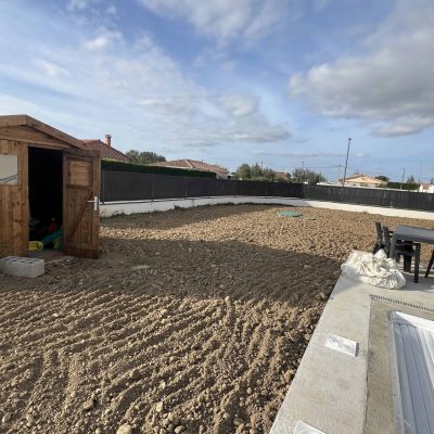 Terrassement de jardin avec nivellement du sol près de la piscine et de l’abri de jardin Légende : Nivellement et préparation de terrain autour de la piscine avant aménagement extérieur.